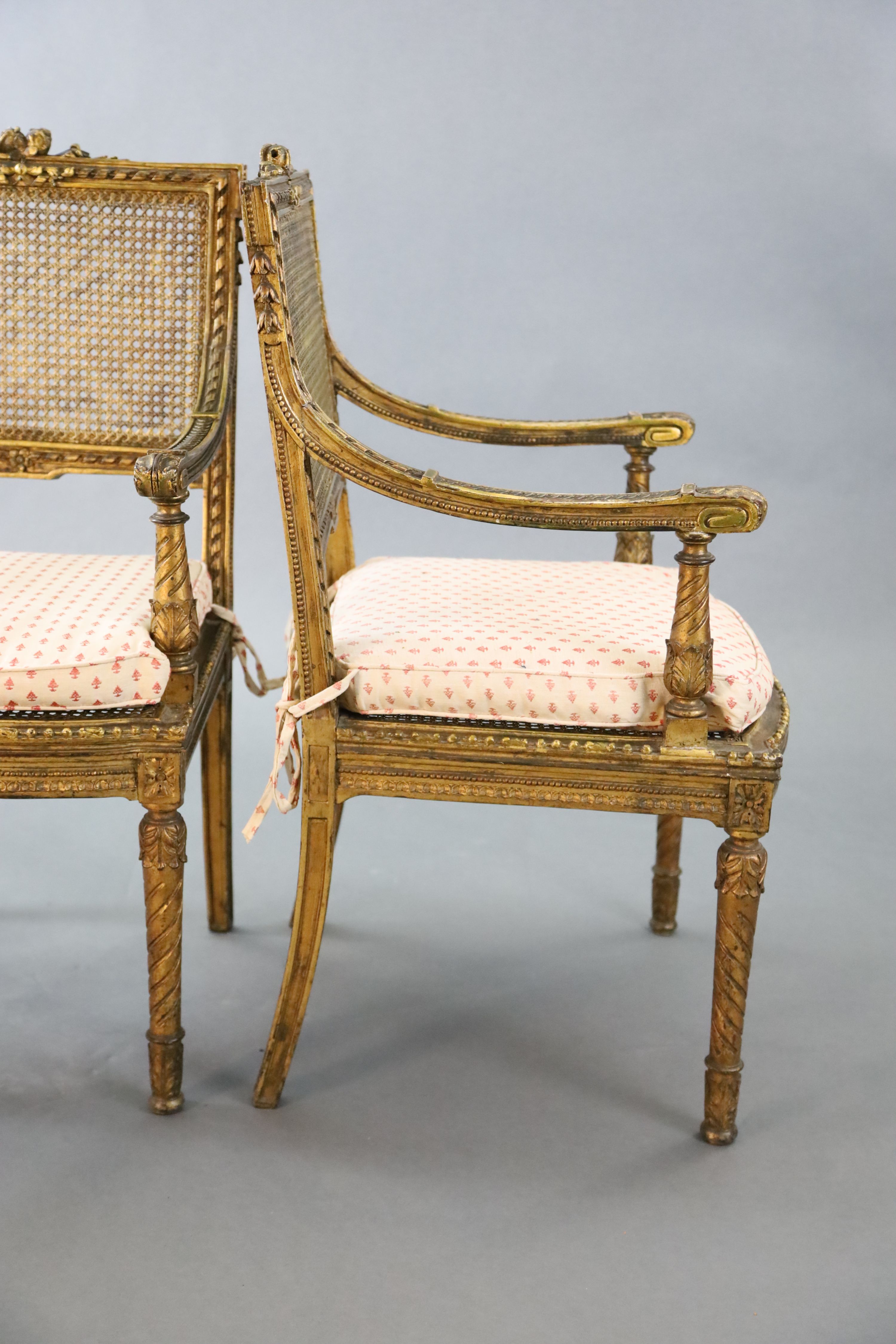 A pair of Louis XVI style walnut giltwood fauteuils, W.1ft 10in. D.1ft 9in. H.3ft 1in.